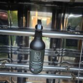 Riebalų valiklio butelis ant metalinių strypų